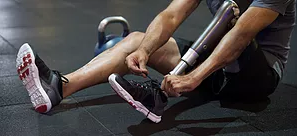 Man ties his shoe on a prosthetic leg.